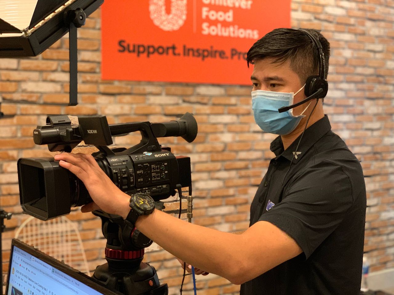 service-02 Professional videographer with headset operating camera in an indoor studio setting.